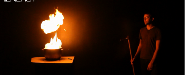 A science presenter safely observes the burning of a fuel